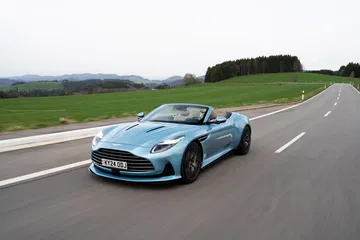 Aston Martin DB12 Volante captado en pleno dinamismo, mostrando su elegante silueta y frontal exclusivo.