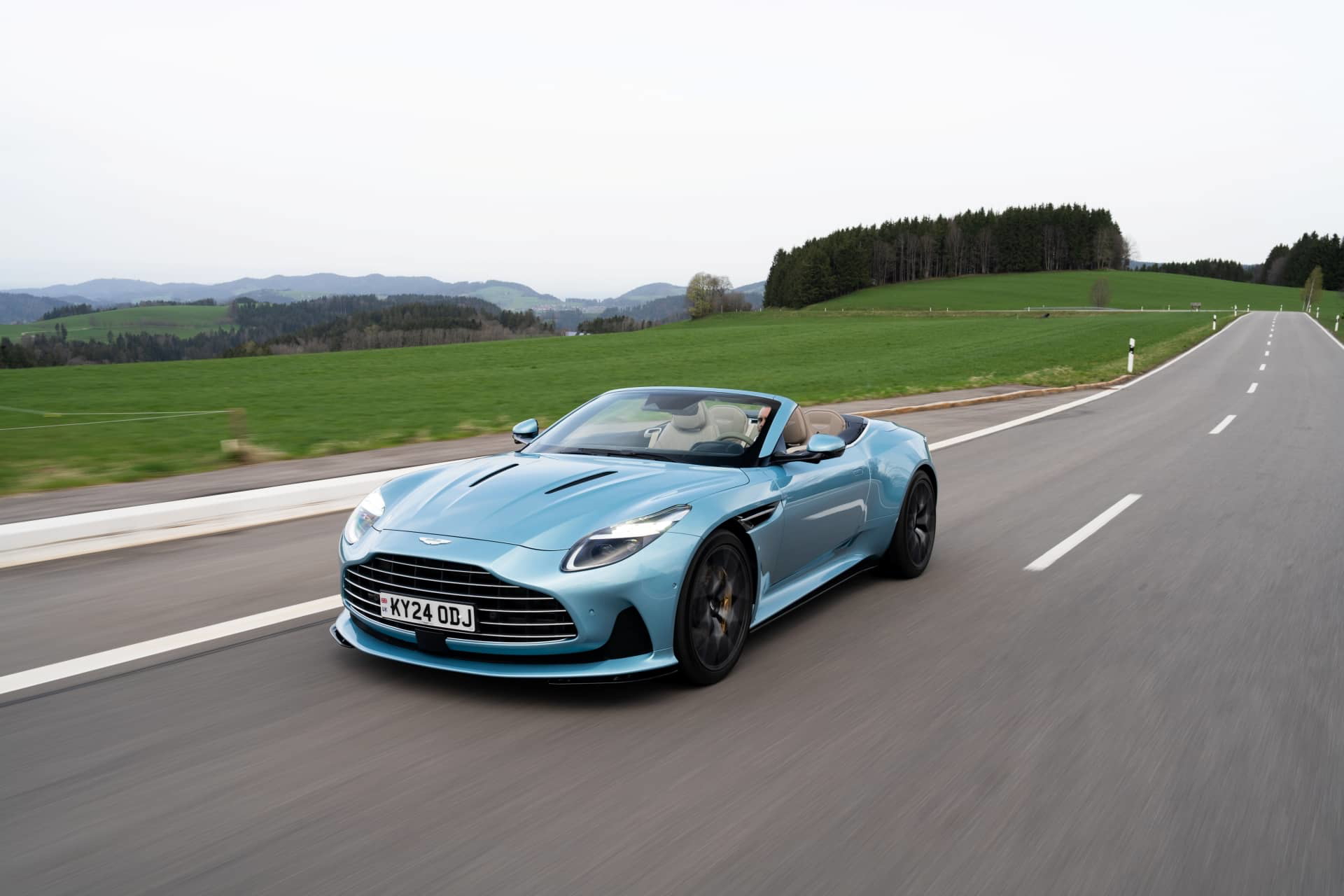 Aston Martin DB12 Volante captado en pleno dinamismo, mostrando su elegante silueta y frontal exclusivo.