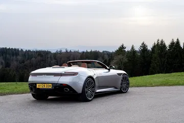 Vista trasera-lateral del Aston Martin DB12 Volante, destacando su diseño elegante y capota plegable.