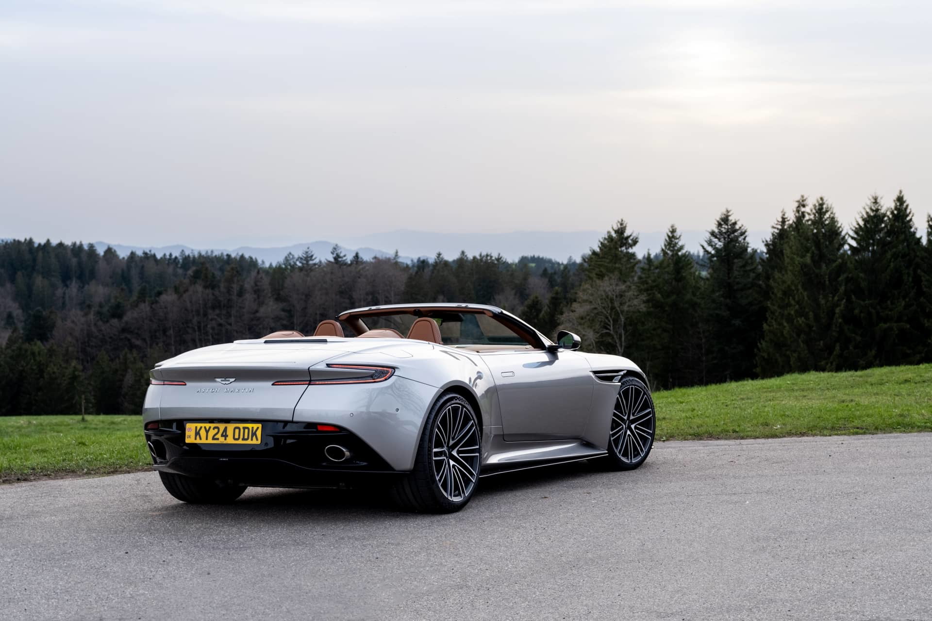 Vista trasera-lateral del Aston Martin DB12 Volante, destacando su diseño elegante y capota plegable.