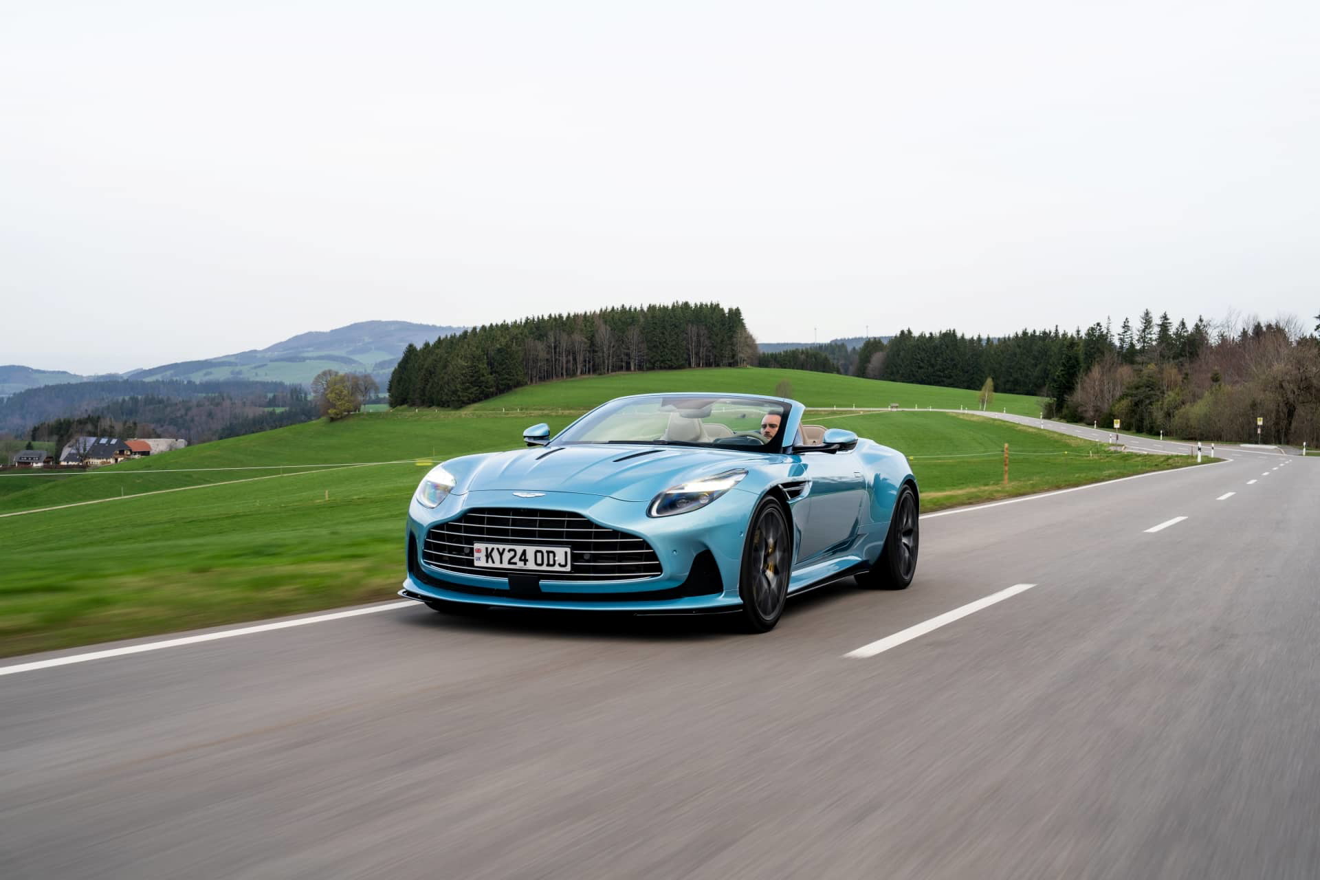 Vista dinámica del Aston Martin DB12 Volante mostrando su perfil elegante y agresivo frontal.