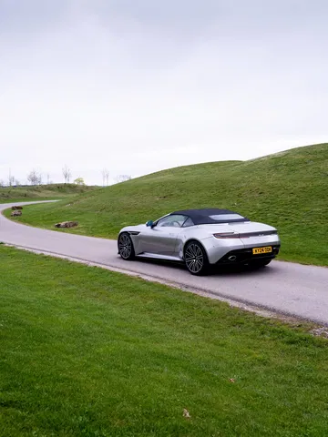 Vista trasera lateral del Aston Martin DB12 Volante mostrando su elegante diseño y proporciones.