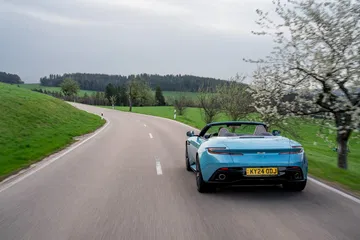Vista dinámica del Aston Martin DB12 Volante mostrando sus líneas elegantes y deportivas.