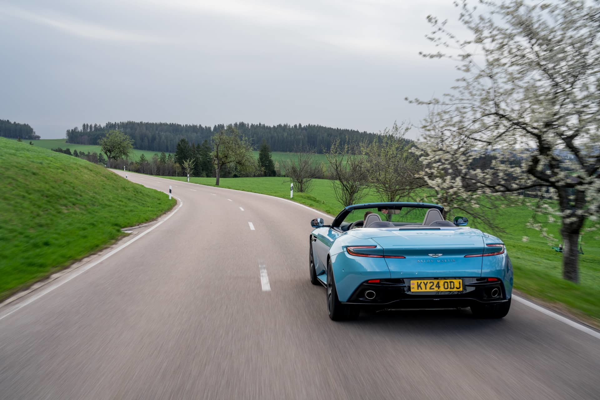 Vista dinámica del Aston Martin DB12 Volante mostrando sus líneas elegantes y deportivas.