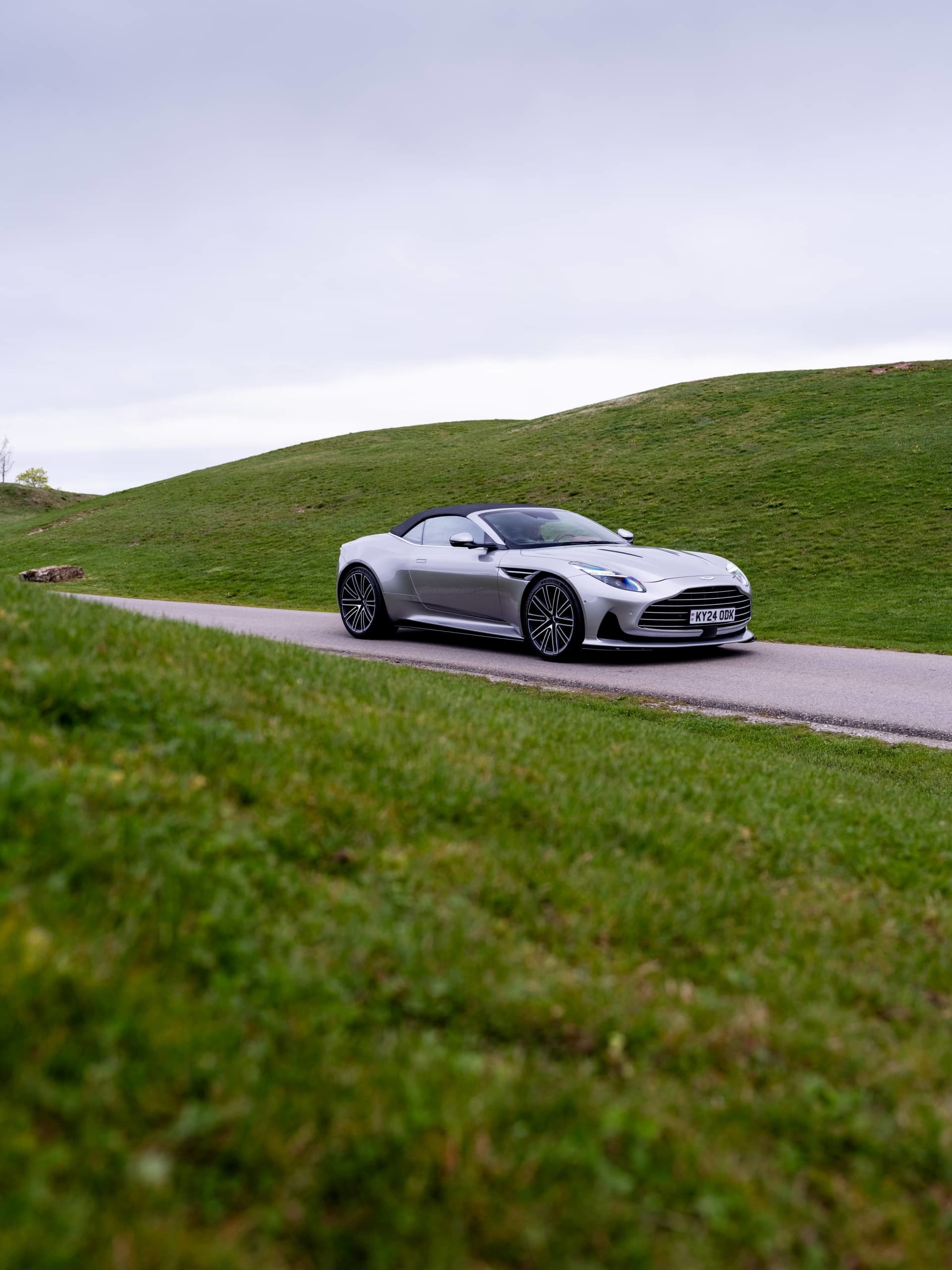 Vista lateral del Aston Martin DB12 Volante, destacando su línea y diseño elegante.