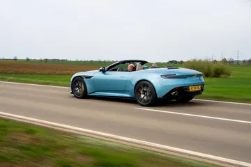 Aston Martin DB12 Volante 2024 capturado en acción, perfil elegante y dinámico