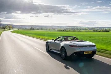 Aston Martin DB12 Volante en movimiento, mostrando diseño y desempeño.