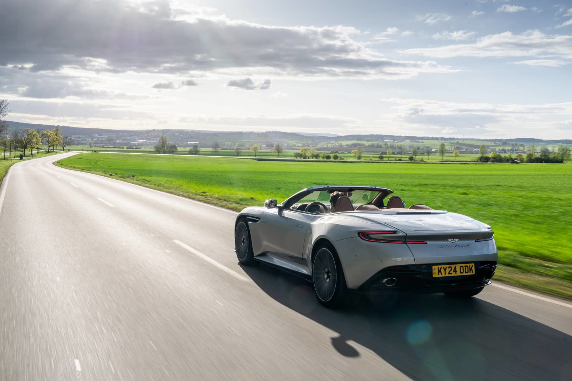 Aston Martin DB12 Volante en movimiento, mostrando diseño y desempeño.