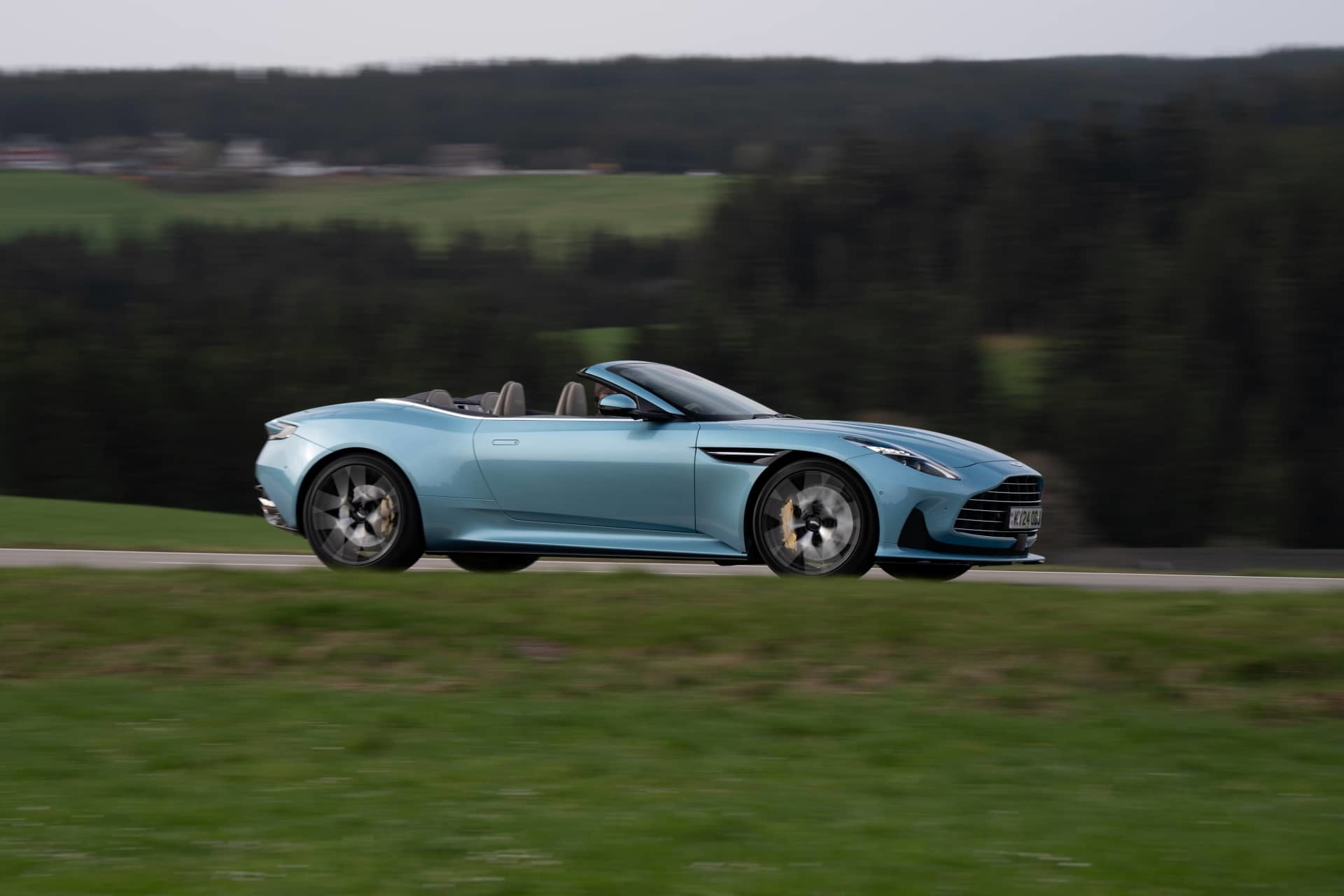 Aston Martin DB12 Volante capturado en acción, demostrando su elegante silueta.