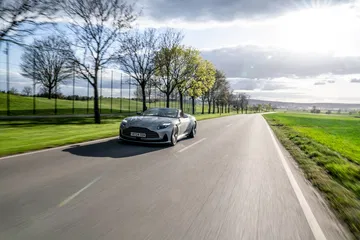 Aston Martin DB12 Volante capturado en pleno dinamismo, destacando su robustez y elegancia.