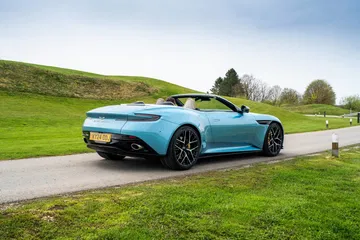 Vista trasera y lateral del Aston Martin DB12 Volante en ambiente natural.