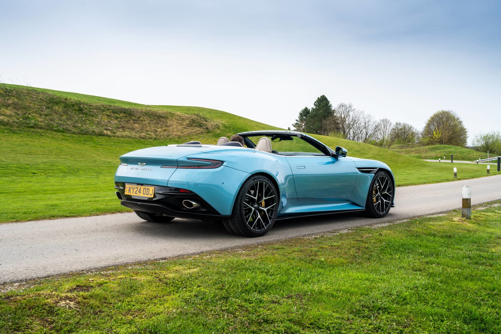 Vista trasera y lateral del Aston Martin DB12 Volante en ambiente natural.