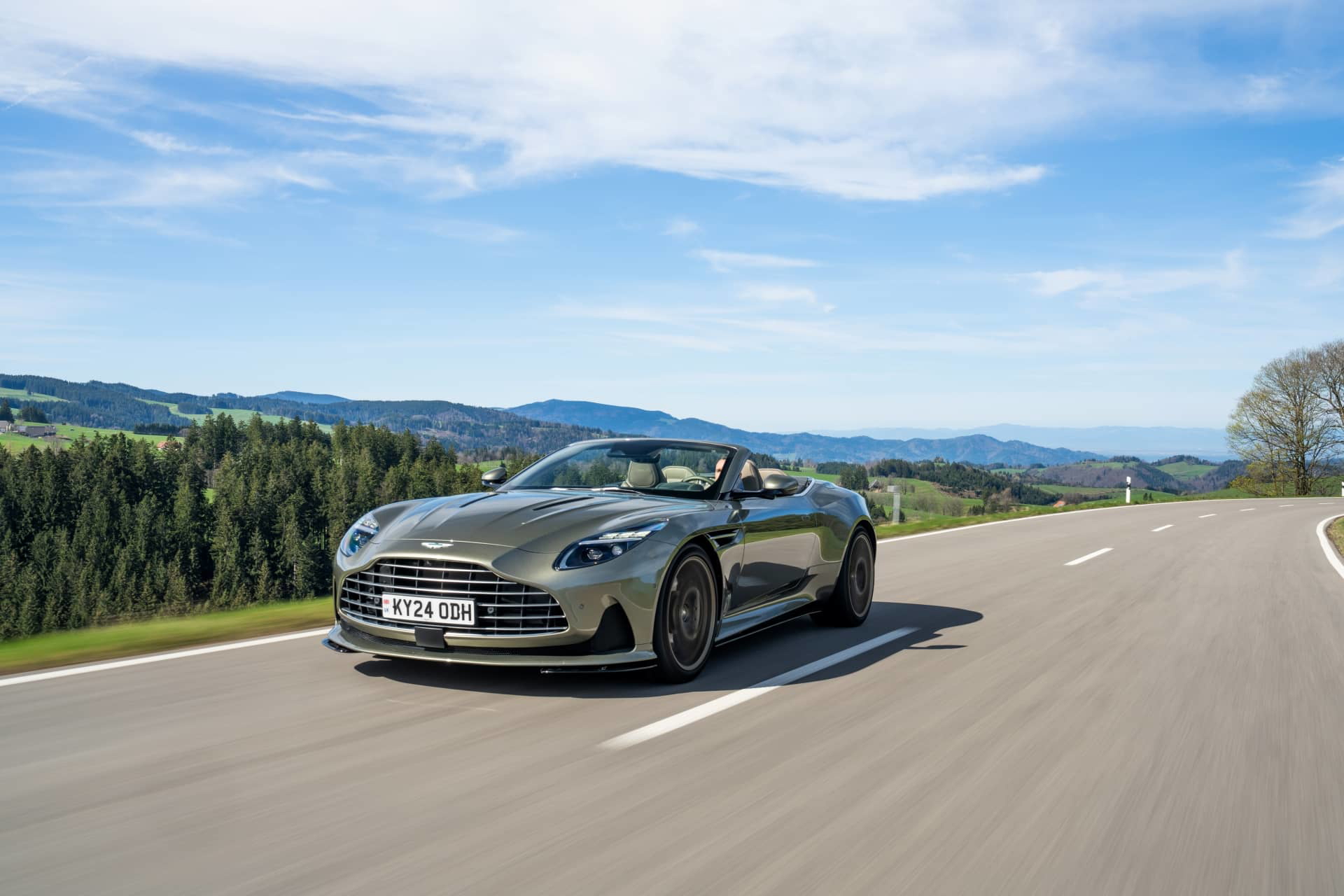 El Aston Martin DB12 Volante capturado en movimiento, mostrando su elegante diseño.
