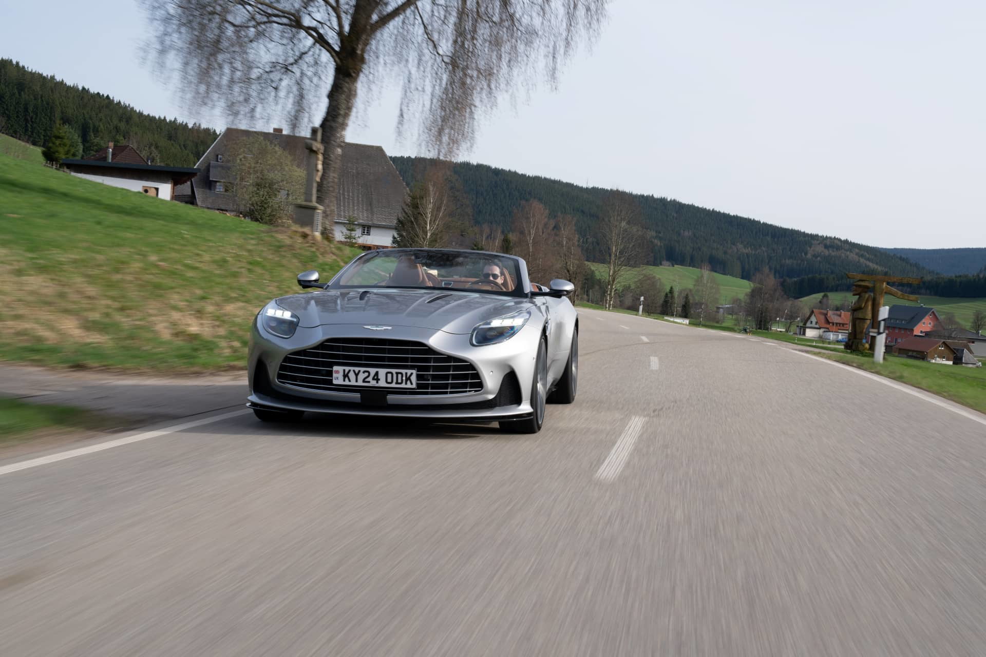 Captura dinámica del Aston Martin DB12 Volante en carretera abierta.