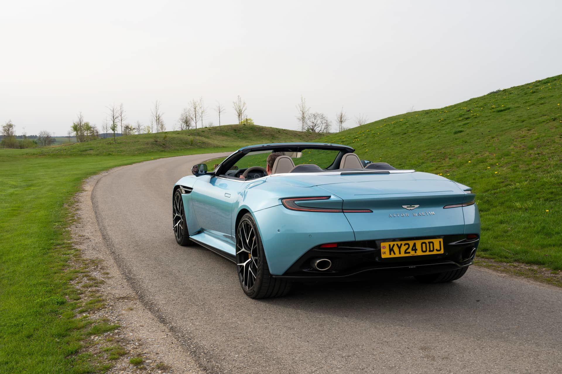Vista trasera y lateral del Aston Martin DB12 Volante mostrando su diseño y líneas aerodinámicas.