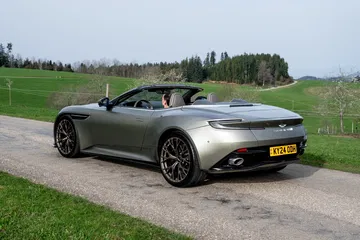Vista trasera lateral del Aston Martin DB12 Volante 2024 en carretera
