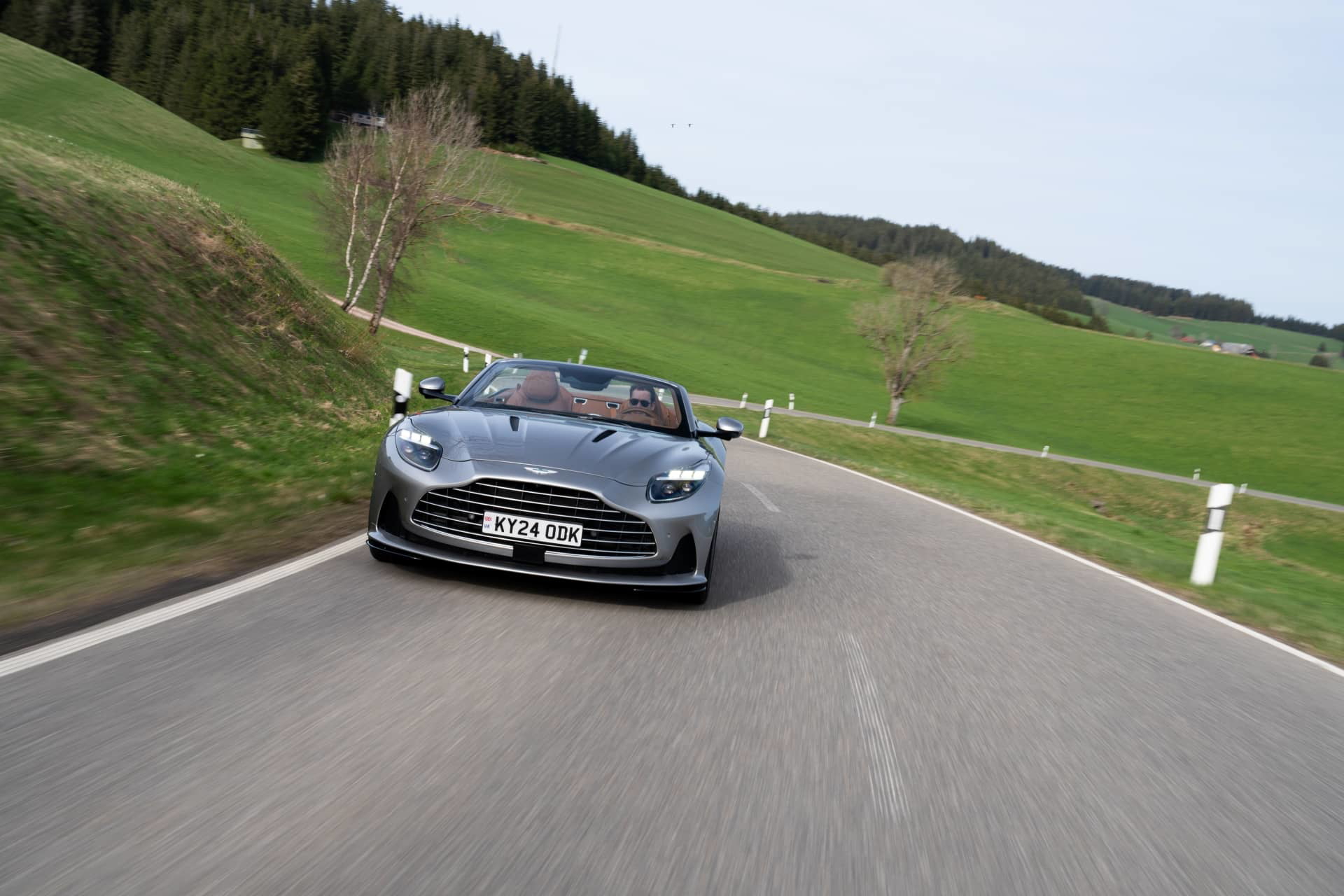 El Aston Martin DB12 Volante capturado en dinámica prueba, mostrando su elegante diseño y prestancia.