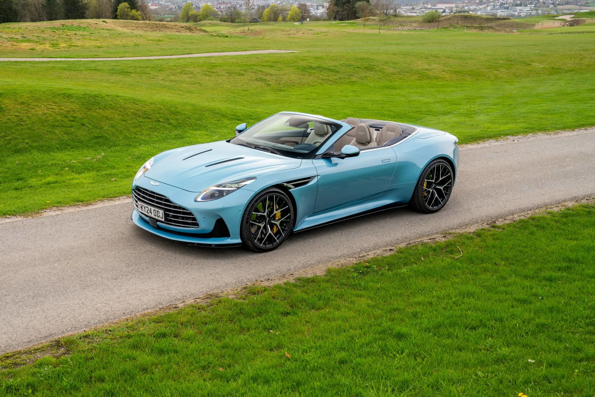 Vista lateral del Aston Martin DB12 Volante 2024 posando majestuosamente.