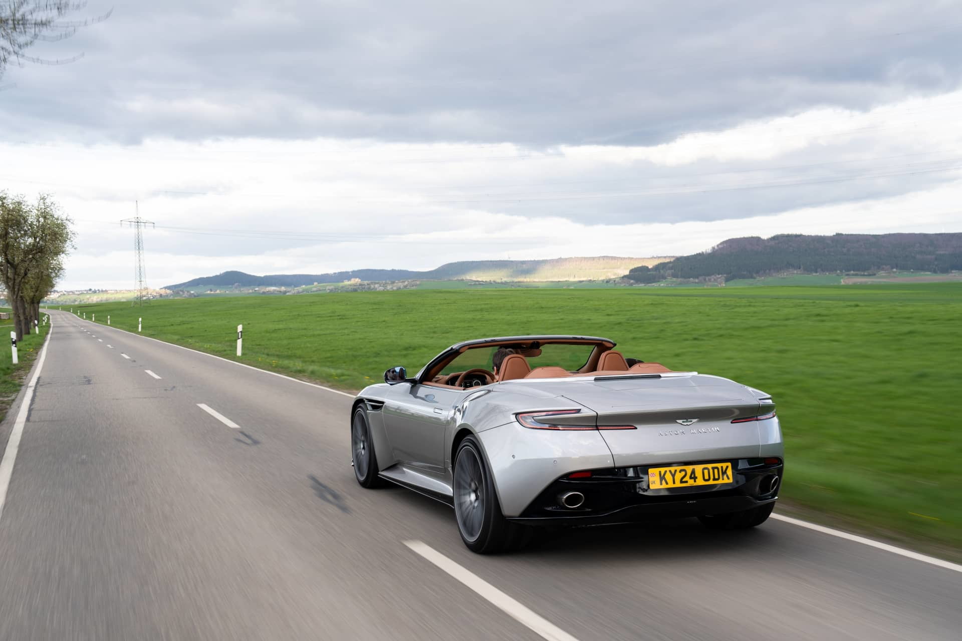 Vista dinámica del Aston Martin DB12 Volante mostrando su silueta y diseño trasero.