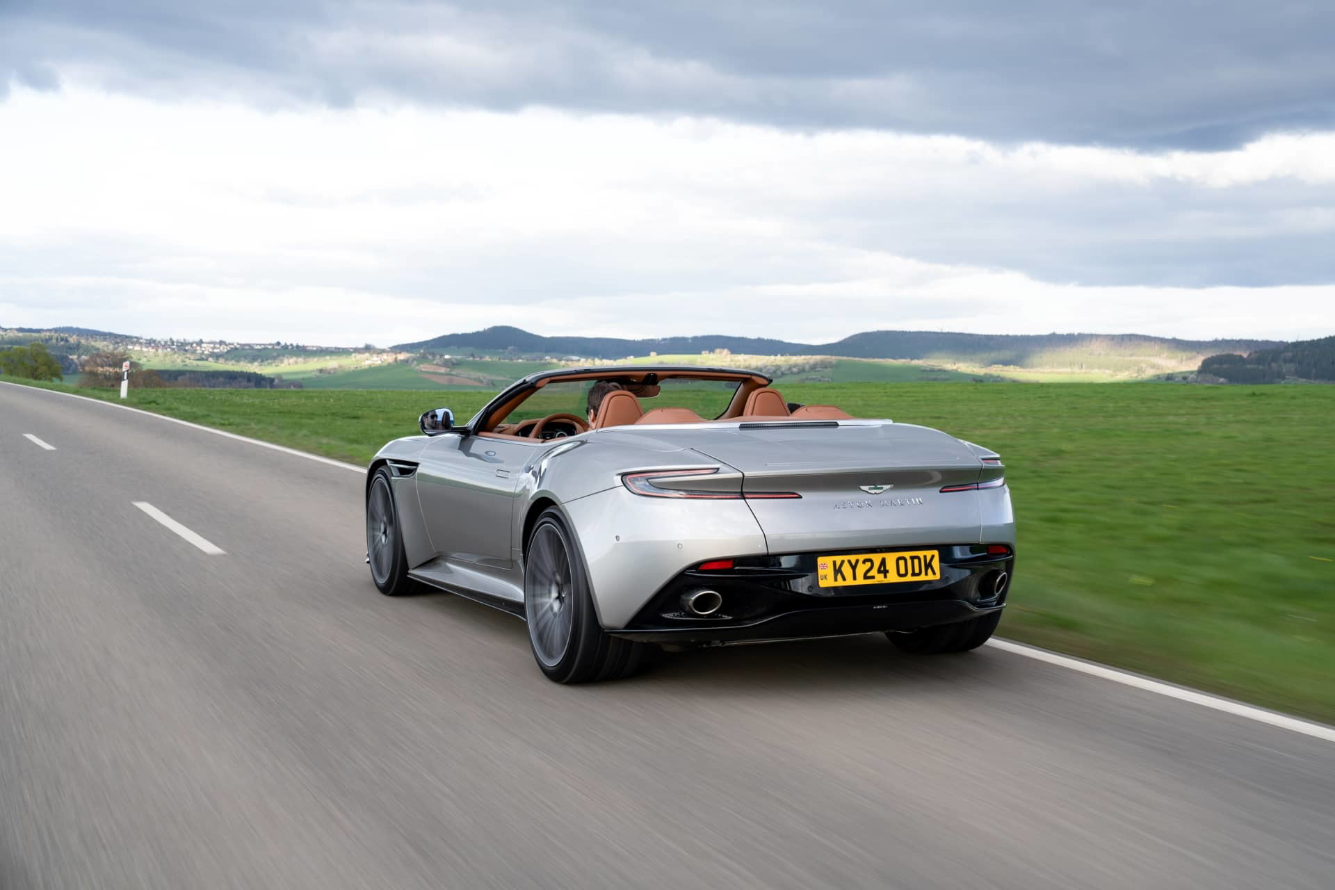 Vista dinámica del Aston Martin DB12 Volante mostrando su elegancia y líneas deportivas.