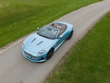 Captura aérea del Aston Martin DB12 Volante mostrando su diseño frontal y perfil lateral.