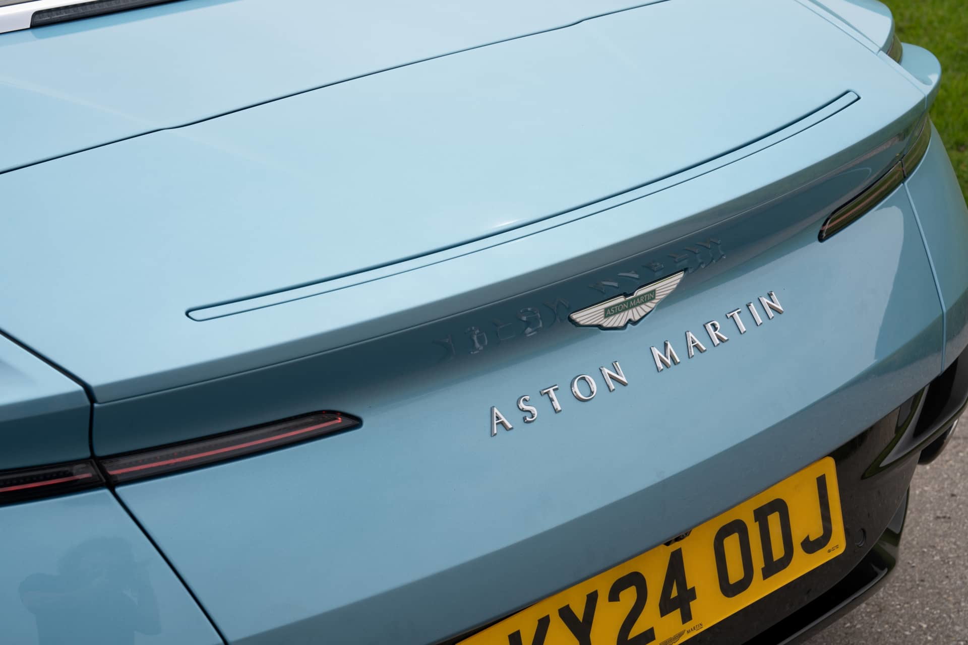Vista trasera parcial del Aston Martin DB12 Volante destacando su distintivo.