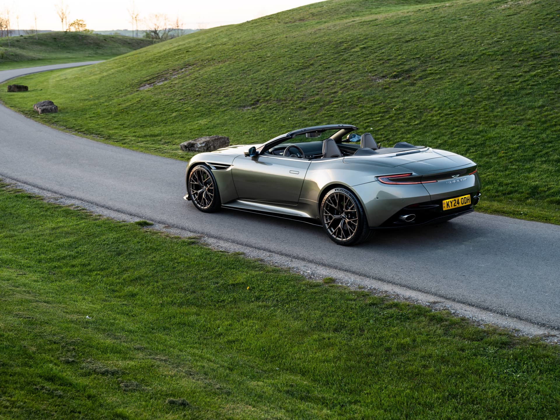 Elegante Aston Martin DB12 Volante capturado en su plenitud, destacando las líneas fluidas y diseño deportivo.
