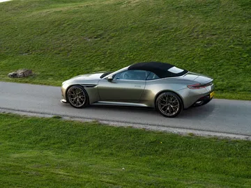Vista lateral y trasera del Aston Martin DB12 Volante en movimiento.