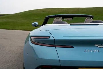 Vista lateral trasera del Aston Martin DB12 Volante con capota abierta.