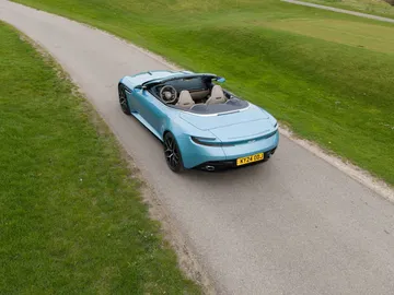 Vista aérea del Aston Martin DB12 Volante mostrando su elegante silueta y capota plegable.