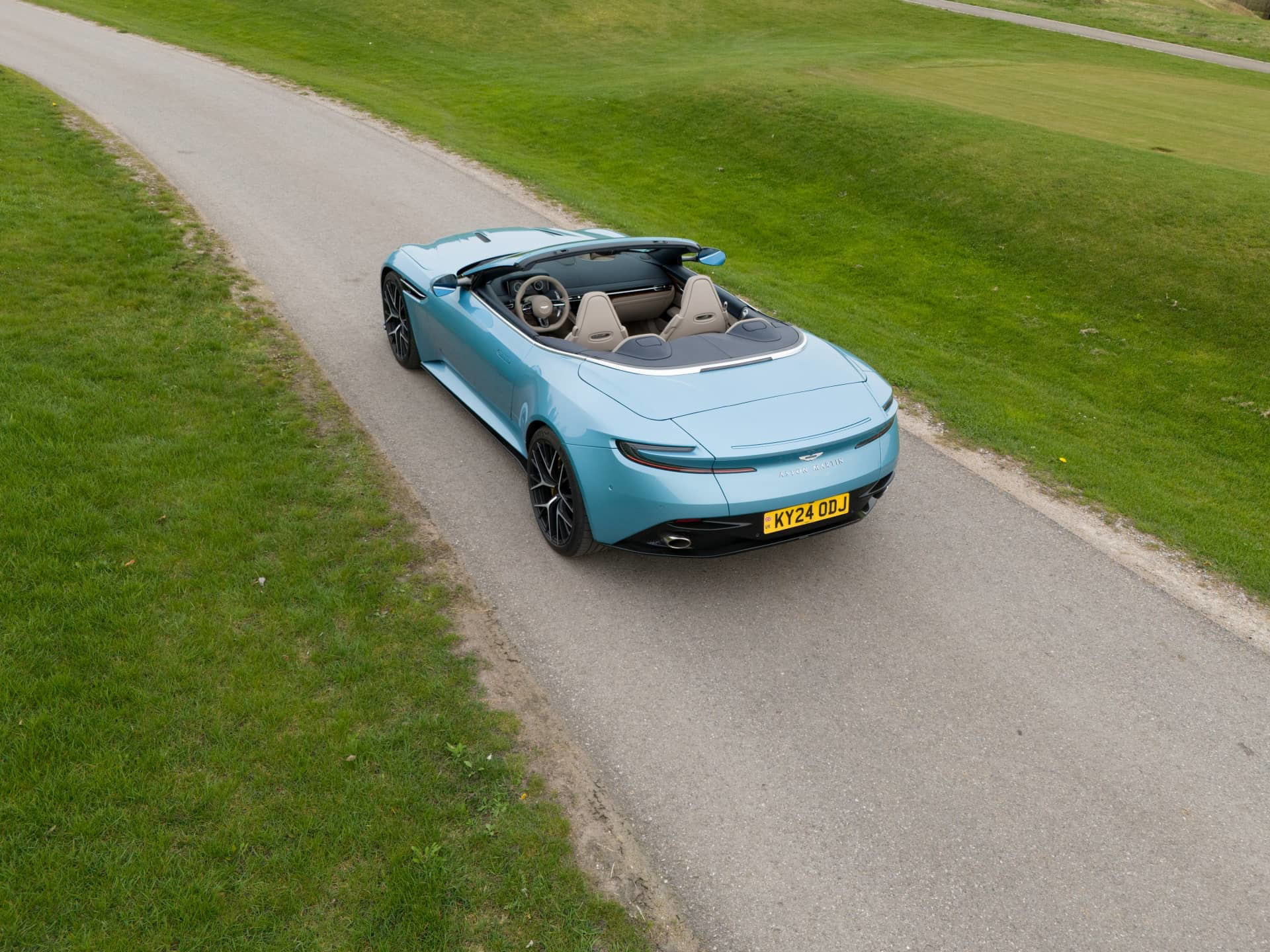 Vista aérea del Aston Martin DB12 Volante mostrando su elegante silueta y capota plegable.
