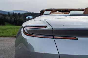 Imagen muestra detalle trasero Aston Martin DB12 Volante, iluminación LED sofisticada.