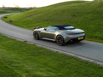 El Aston Martin DB12 Volante muestra su elegancia y diseño deportivo en ambiente natural.