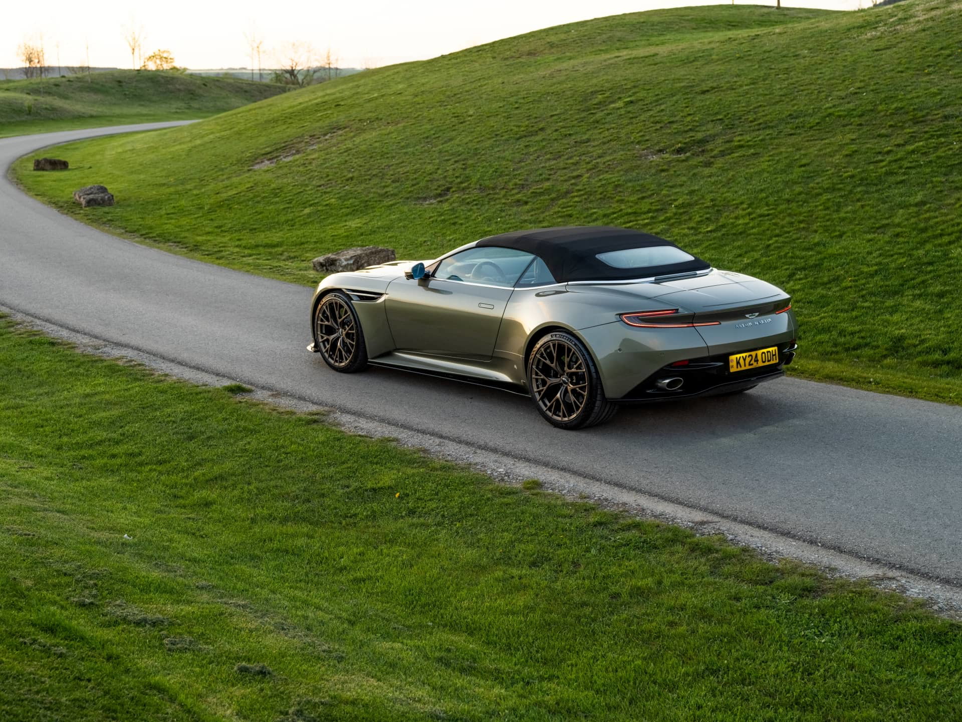 El Aston Martin DB12 Volante muestra su elegancia y diseño deportivo en ambiente natural.
