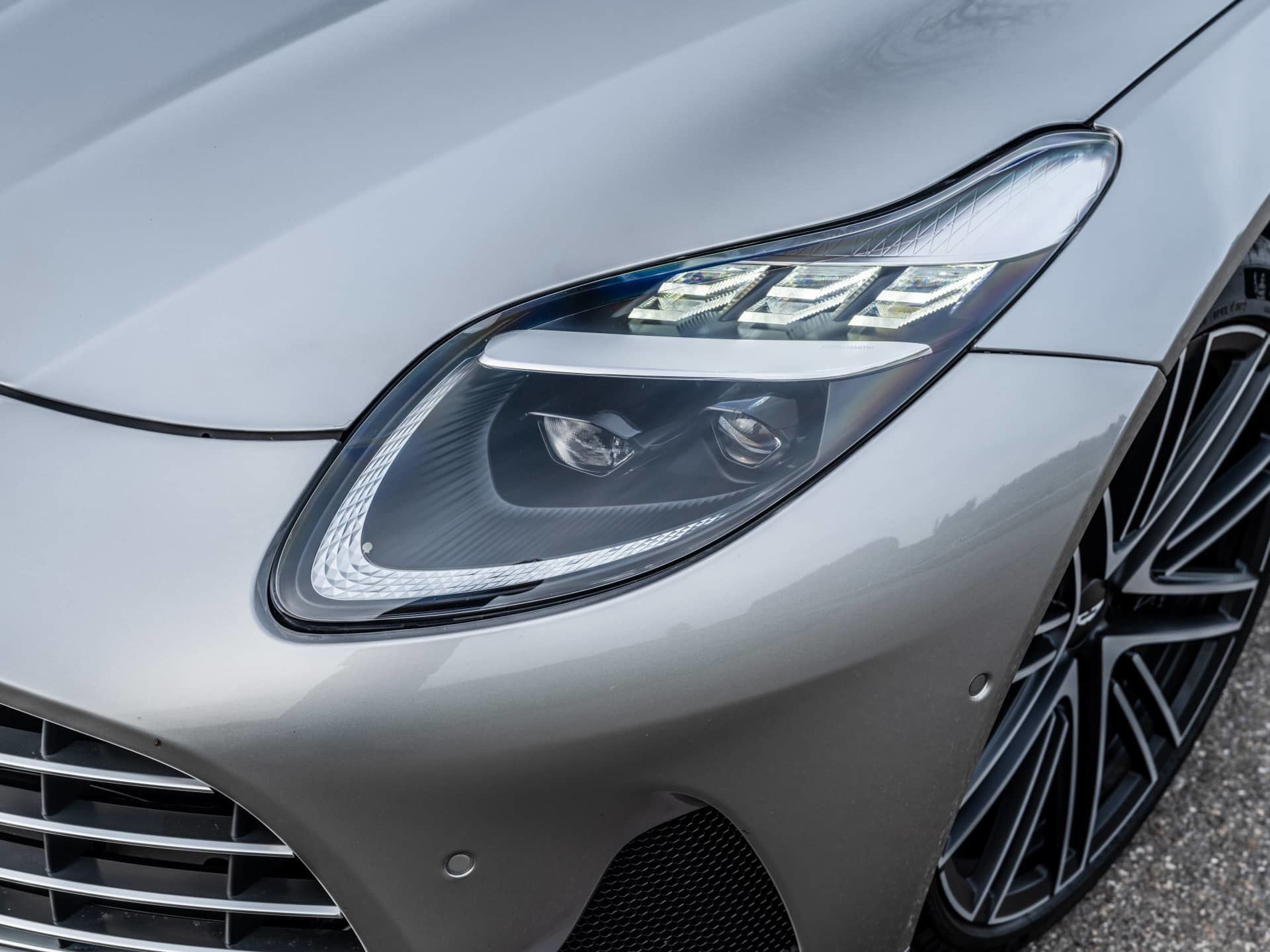 Primer plano del faro delantero del Aston Martin DB12 Volante, destacando su diseño y tecnología LED.