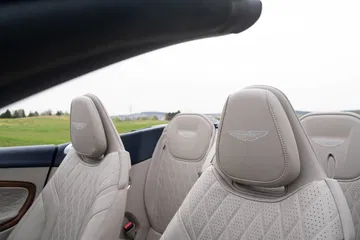 Vista de los asientos de cuero con detalle del emblema de Aston Martin en un DB12 Volante 2024.