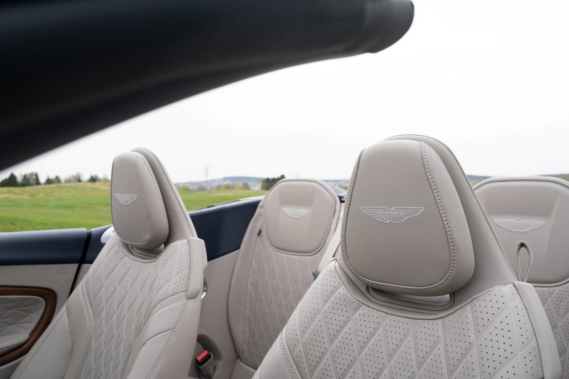 Vista de los asientos de cuero con detalle del emblema de Aston Martin en un DB12 Volante 2024.