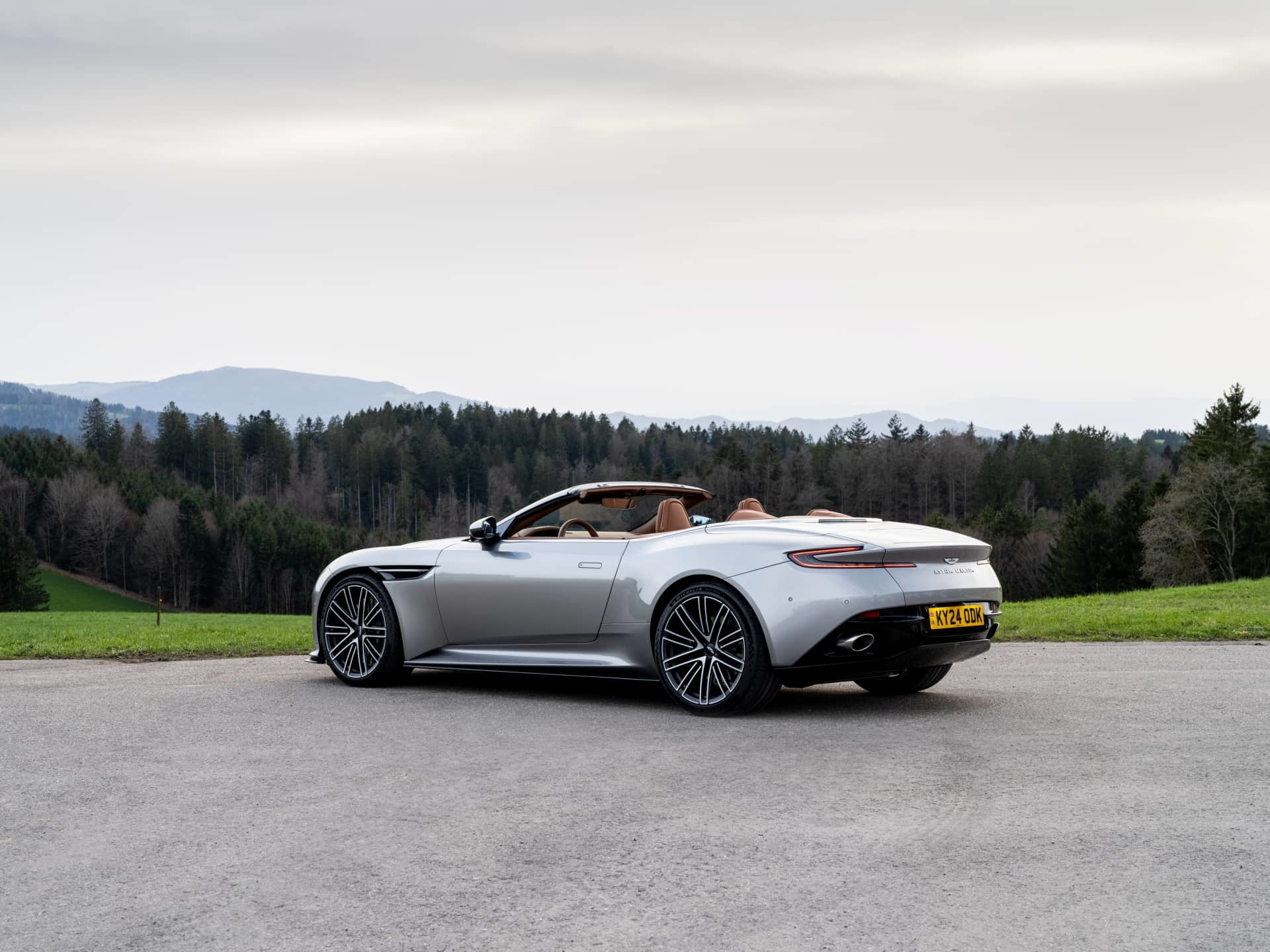 Vista posterior lateral del Aston Martin DB12 Volante, destacando su diseño elegante y dinámico.
