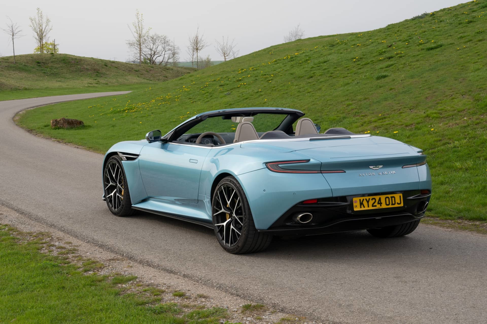 Vista trasera-lateral del Aston Martin DB12 Volante, mostrando su diseño elegante y deportivo.