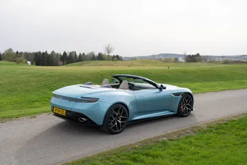Vista trasera lateral del Aston Martin DB12 Volante, resaltando su diseño elegante y deportivo.