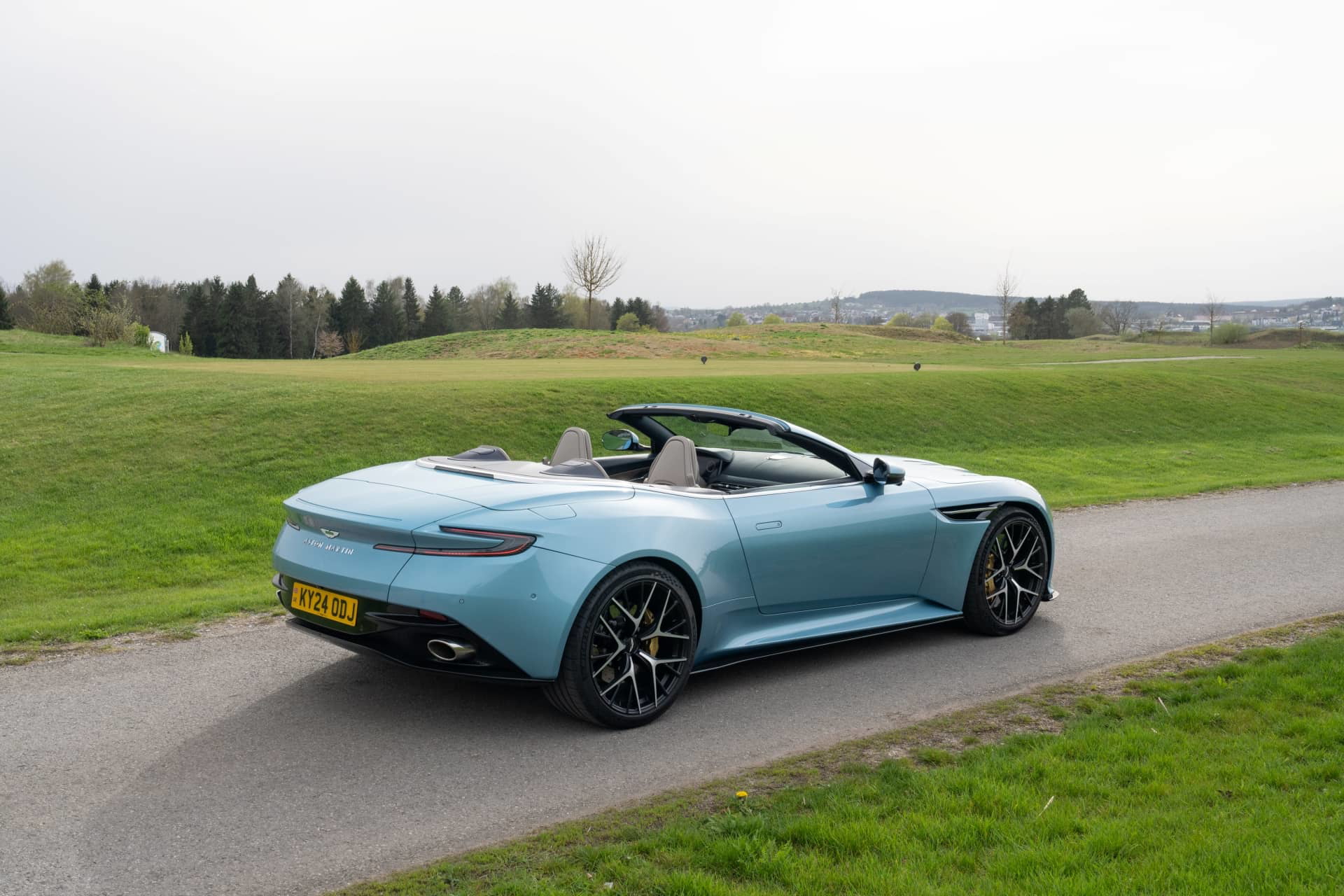Vista trasera lateral del Aston Martin DB12 Volante, resaltando su diseño elegante y deportivo.