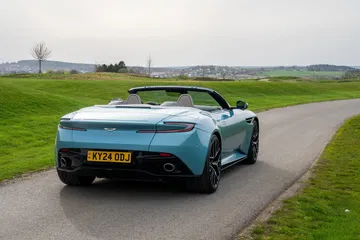 Vista trasera y lateral del Aston Martin DB12 Volante, resaltando su línea deportiva y elegante.