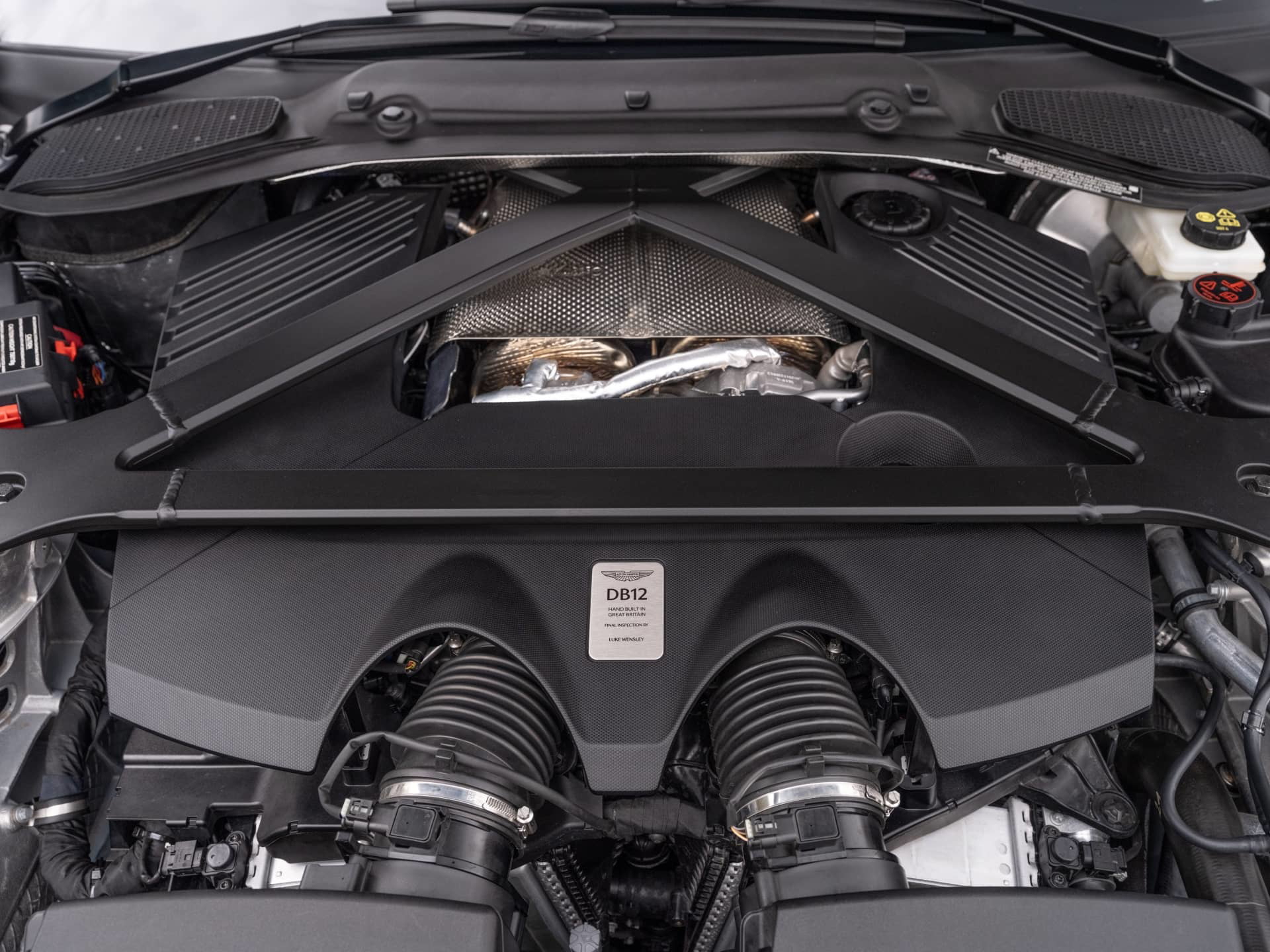 Vista del potente motor V12 del Aston Martin DB12 Volante, un espectáculo de ingeniería.