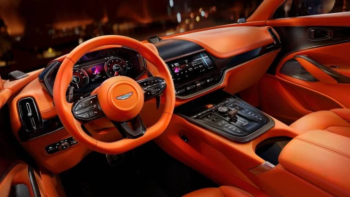 Vista del lujoso habitáculo del Aston Martin DBX707, destacando su tapizado en cuero naranja.