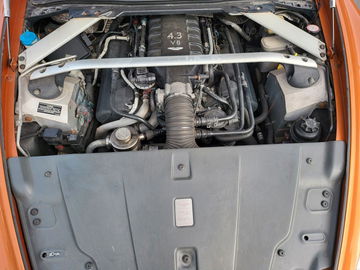 Vista del robusto motor V8 del Aston Martin, signo inequívoco de potencia y rendimiento.