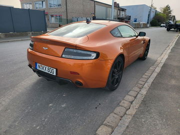 Vista trasera-lateral de un Aston Martin, destacando su diseño deportivo y elegante.