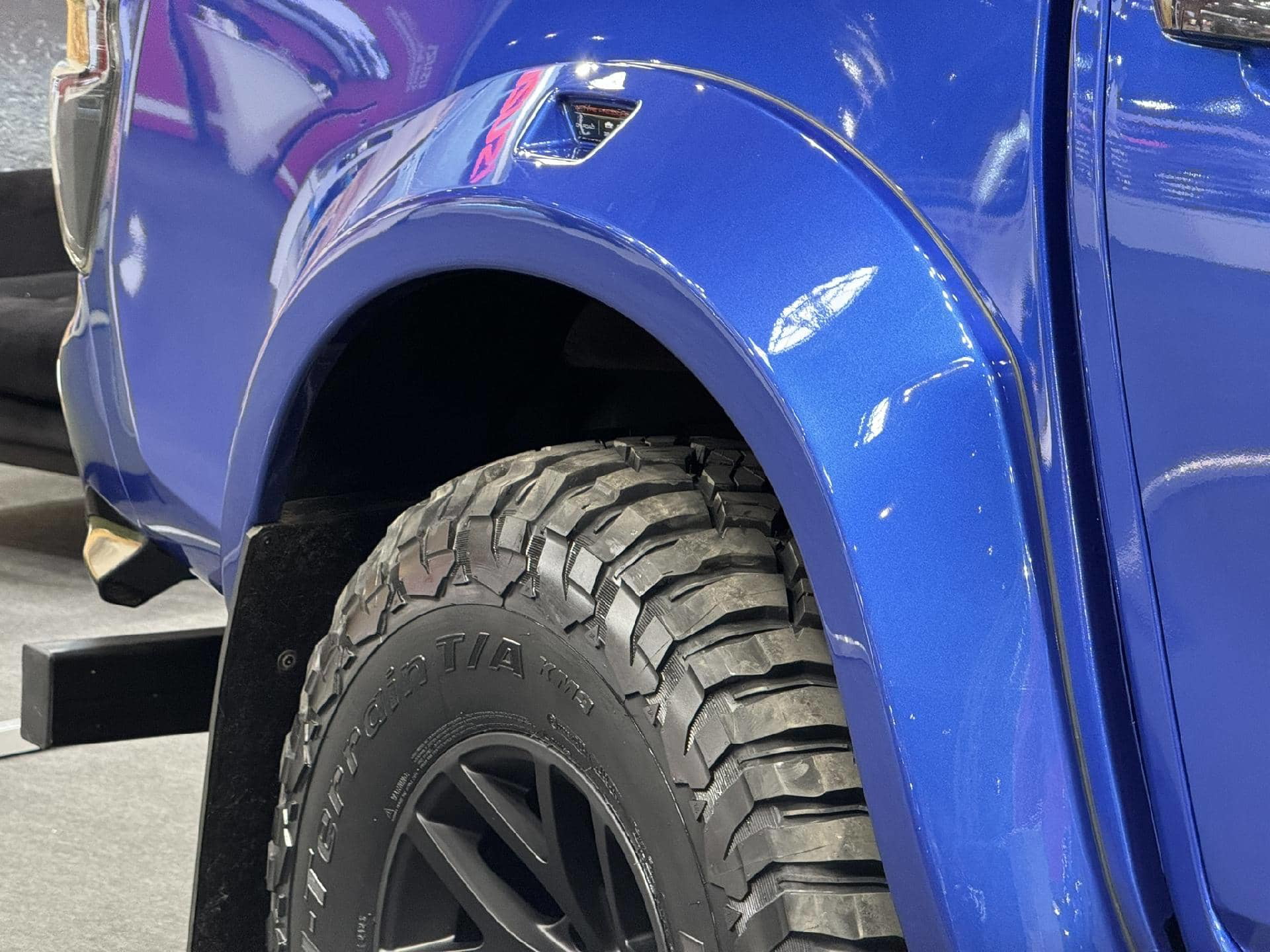 Detalle del paso de rueda con una llanta deportiva y neumático de alto rendimiento.