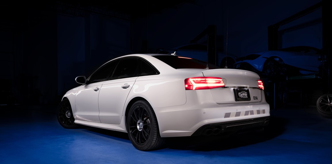 Vista nocturna de un Audi, mostrando claramente su diseño trasero y perfil lateral.