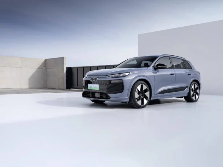 Audi Q6L e-tron capturado en perfil, destacando su diseño futurista y líneas aerodinámicas.
