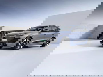 Audi Q6L e-tron capturado en perfil, destacando su diseño futurista y líneas aerodinámicas.